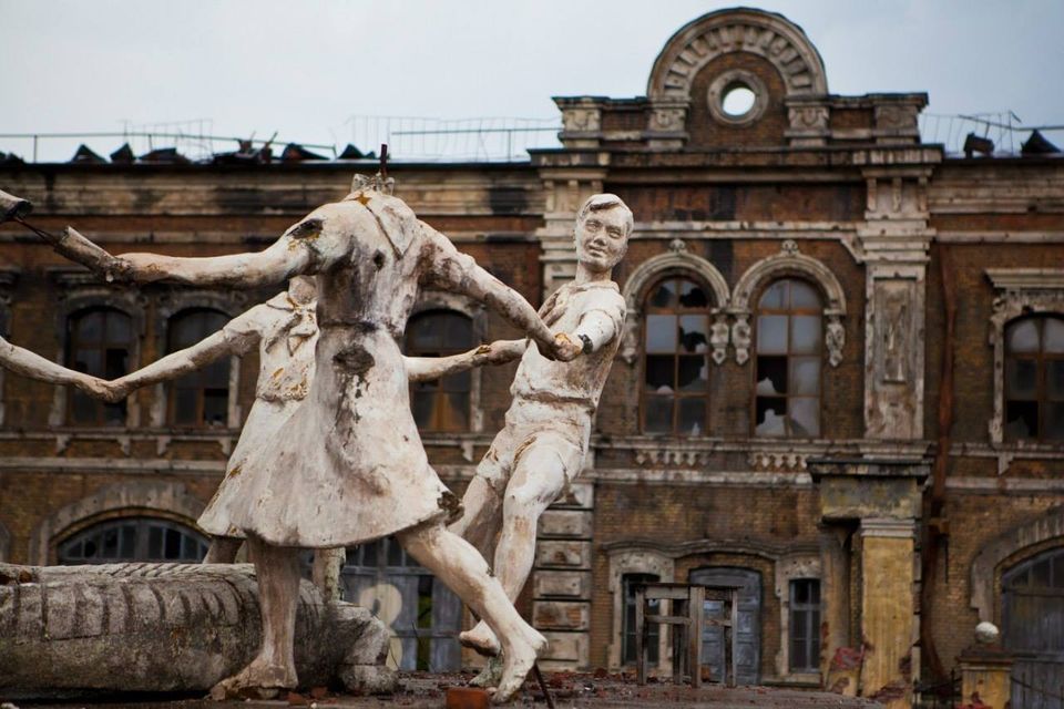 Apgriuvusios skulptūros, vaizduojančios rankomis susikibusius ir šokančius žmones