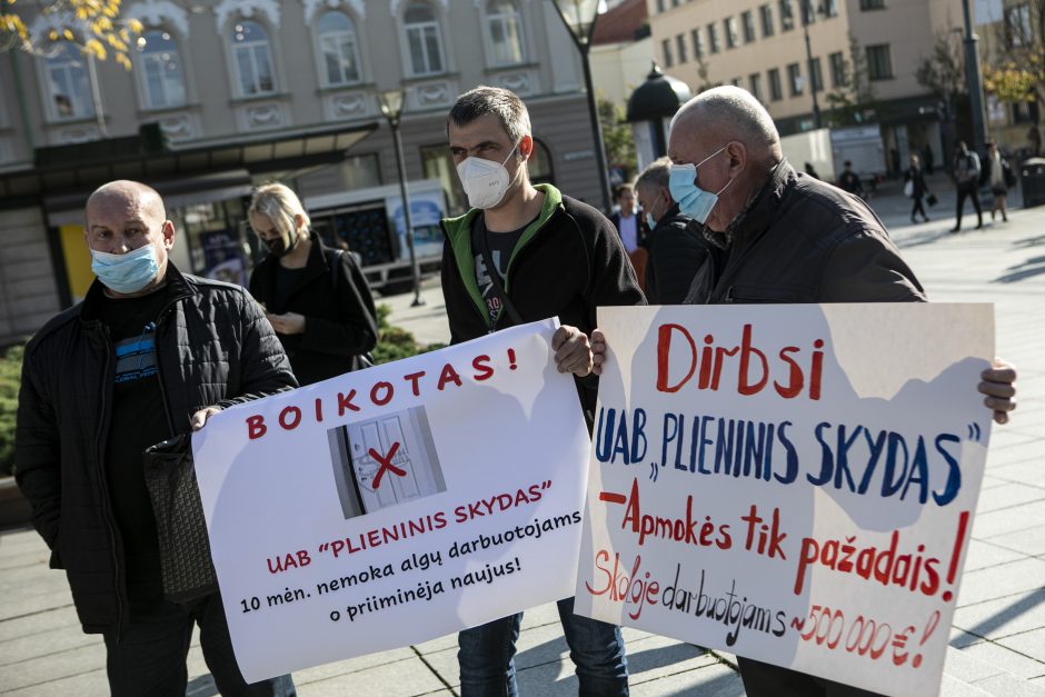 Protestuojantys UAB „Plieninis skydas“ darbuotojai laiko plakatus. Ant vieno užrašyta „Boikotas“, ant kito – „Dirbsi UAB Plienis skydas – apmokės tik pažadais“