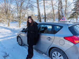 Aldona Juozaitytė stovi prie savo automobilio