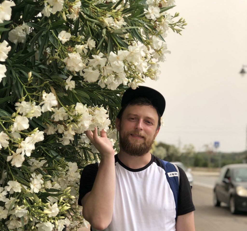 Karolis Dambrauskas prie baltai žydinčių gėlių