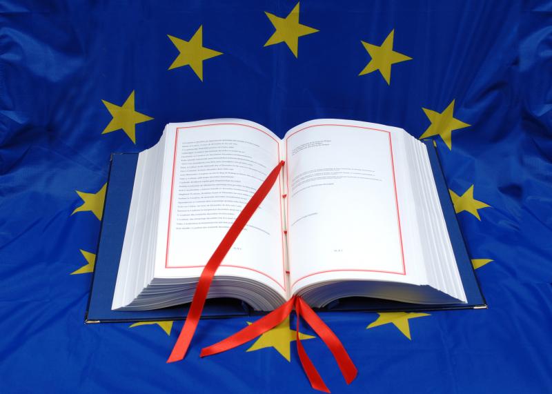 Atversta puošni knyga, padėta ant Europos Sąjungos vėliavos