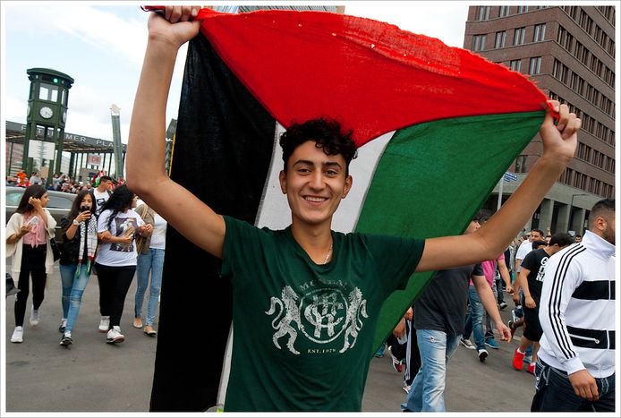 jaunas palestinietis neša Palestinos vėliavą