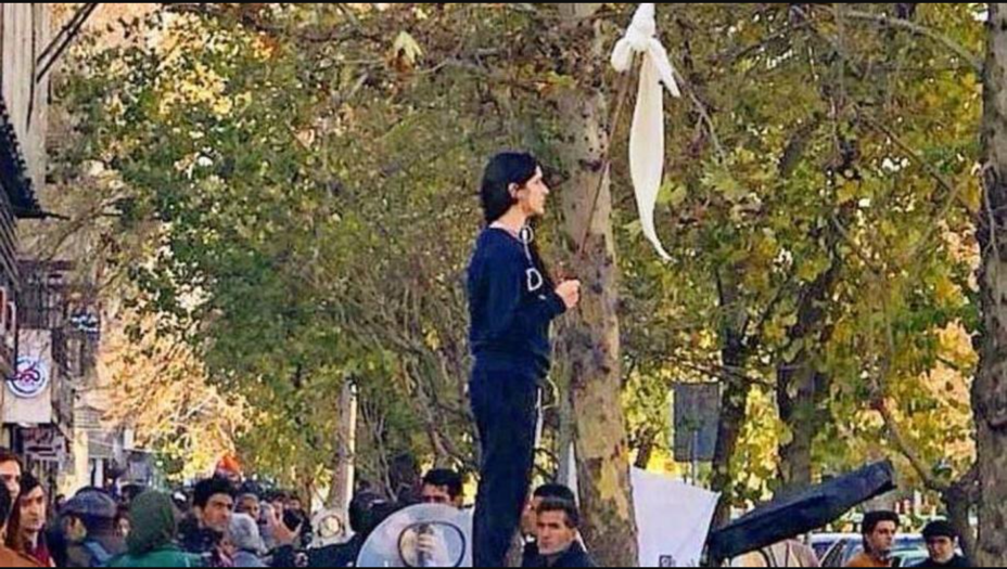 Iranietė stovi aikštėle hidžabą apsukusi ant lazdos