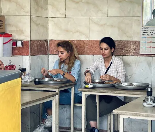 Dvi Iranietės valgo restorane