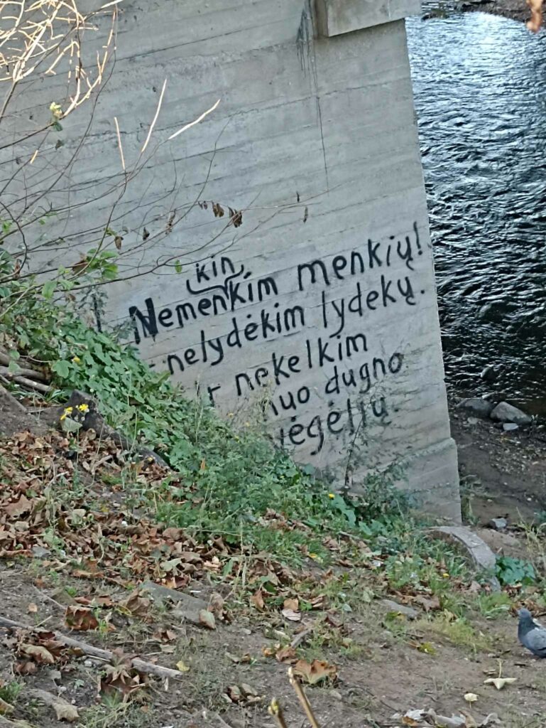 Grafitis ant tilto per Vilnelę: „Nemenkinkim menkių! Nelydėkim lydekų. Ir nekelkim nuo dugno vėgėlių.“