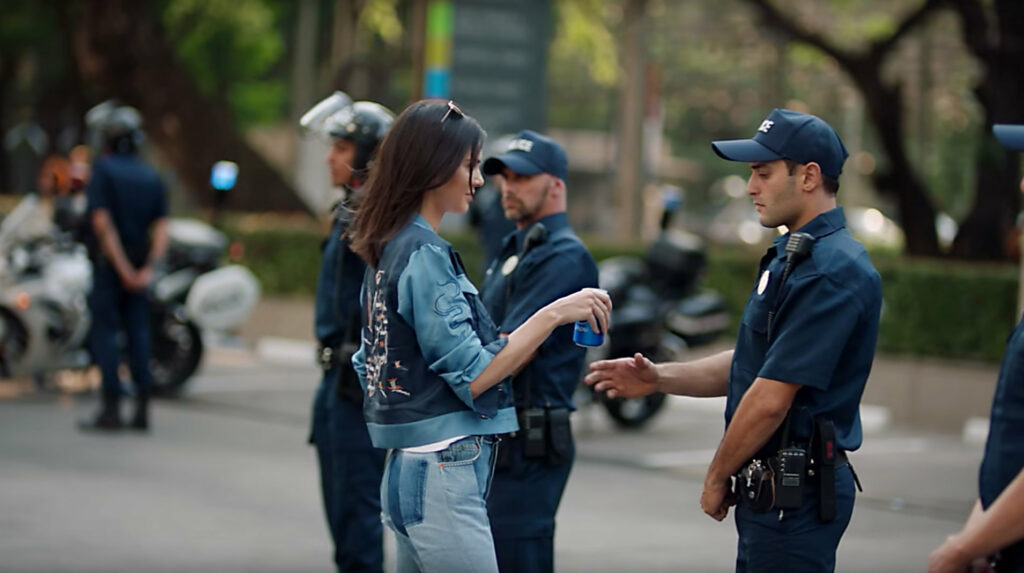Kendall Jenner duoda policininkui "Pepsi" skardinę