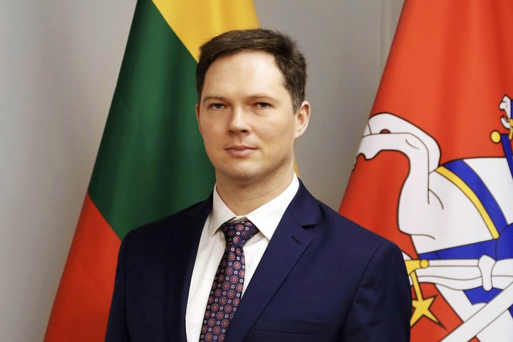 Kristupas Vaitiekūnas Lietuvos vėliavos fone